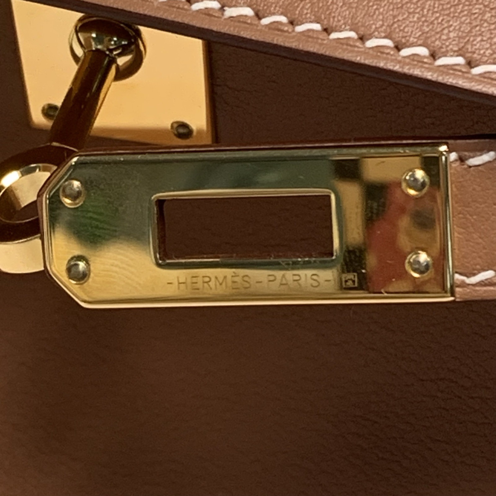 Close-up of the single top handle and shoulder strap hardware on a vintage Hermes Kelly.