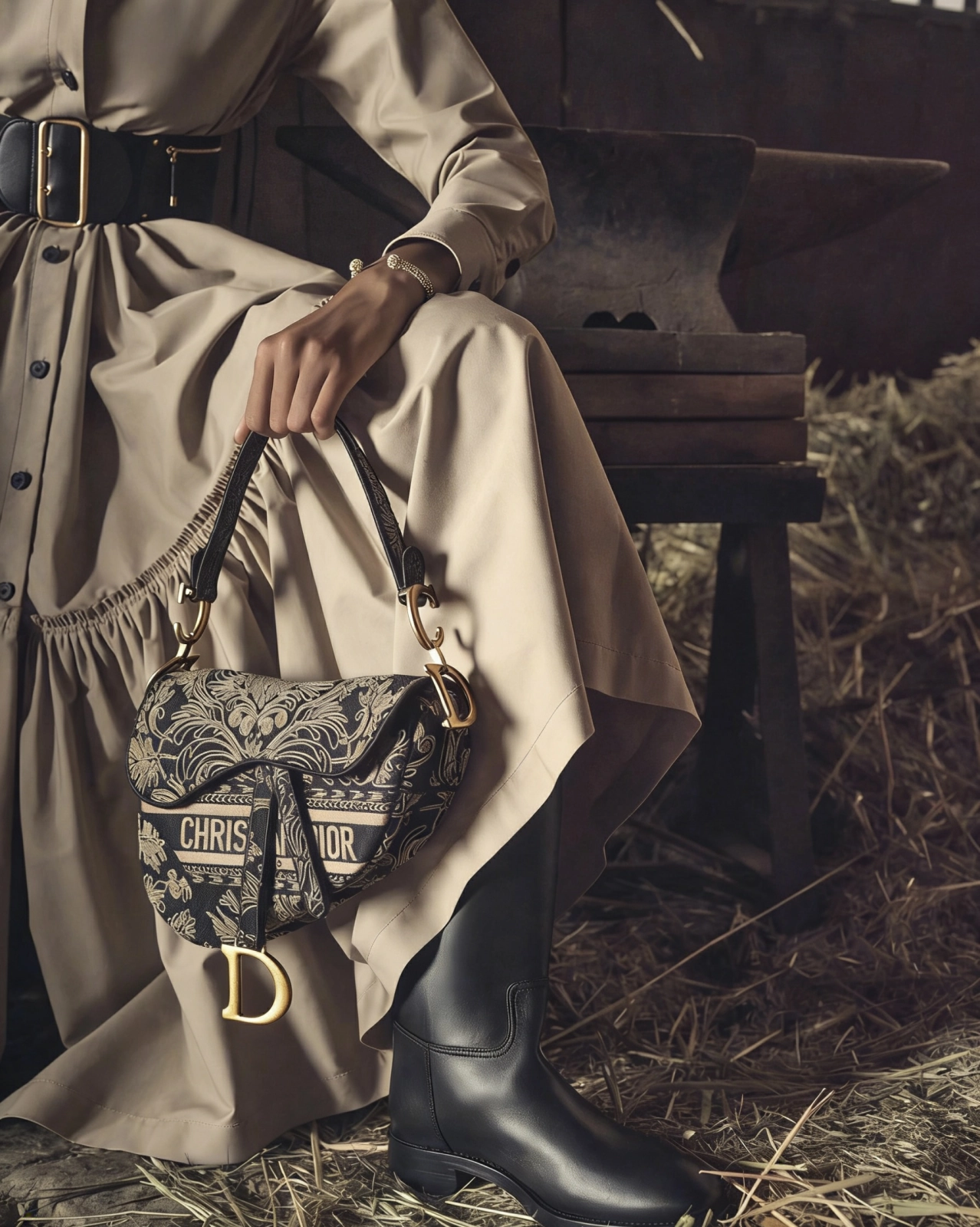 Close-up of the signature gold-tone D stirrup hardware on a Dior Saddle bag.